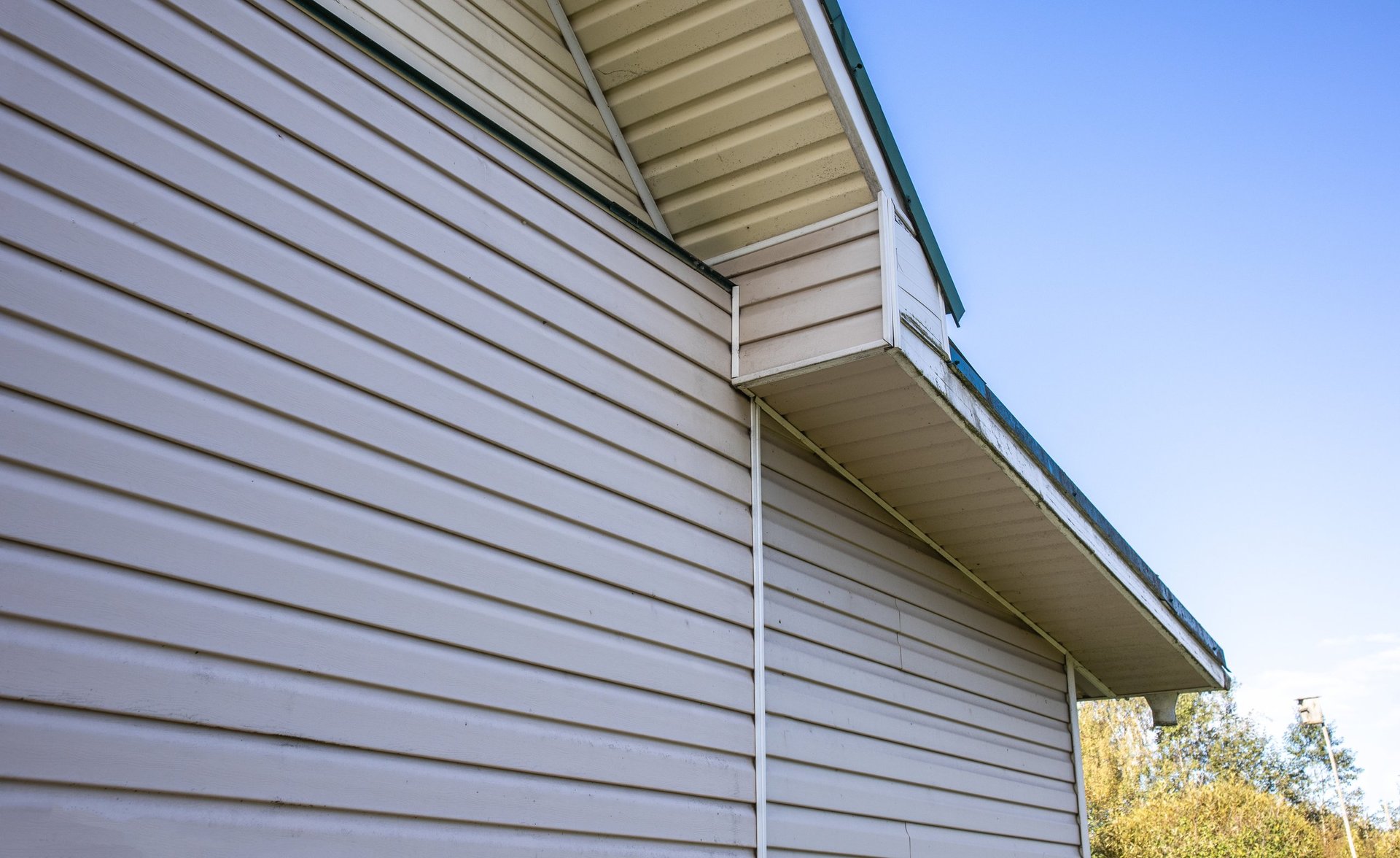 Private house facade with vinyl siding, clean lines, blue sky